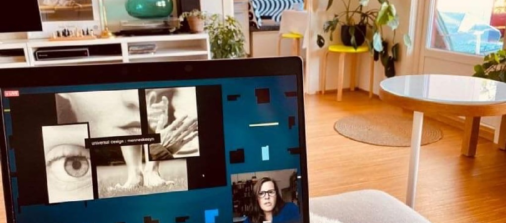 En pc på en sofa i en smuk stue. PÅ skærmen holder Camilla Ryhl oplæg.