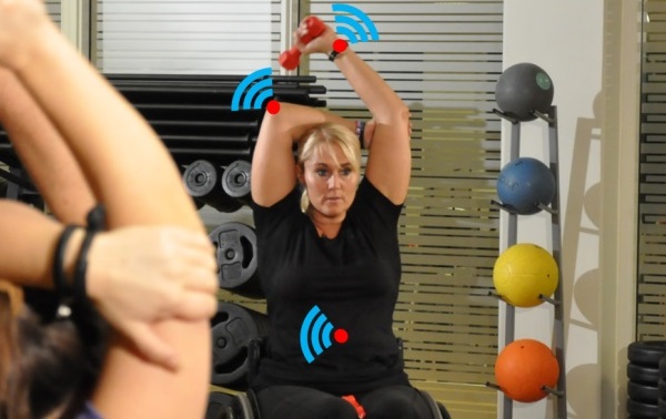 kørestolsbruger træner med håndvægte